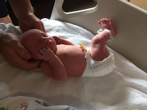 Dr. Adcock gently adjusting a newborn.